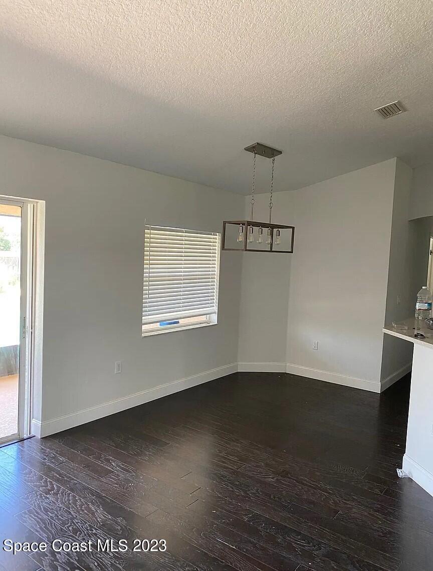 1913 Gloria Circle Palm Bay, FL 32905 - Photo 9 of 18 an empty room with wooden floor and windows
