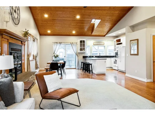a living room with stainless steel appliances kitchen island granite countertop furniture and a wooden floor