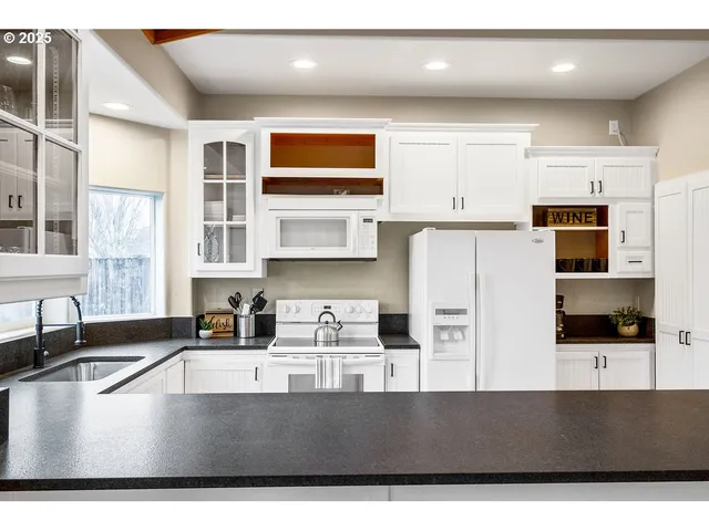 a kitchen with stainless steel appliances a sink a stove a microwave a counter top and cabinets