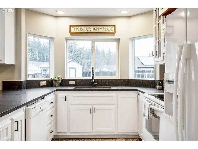 a kitchen with stainless steel appliances granite countertop a sink a stove and a refrigerator
