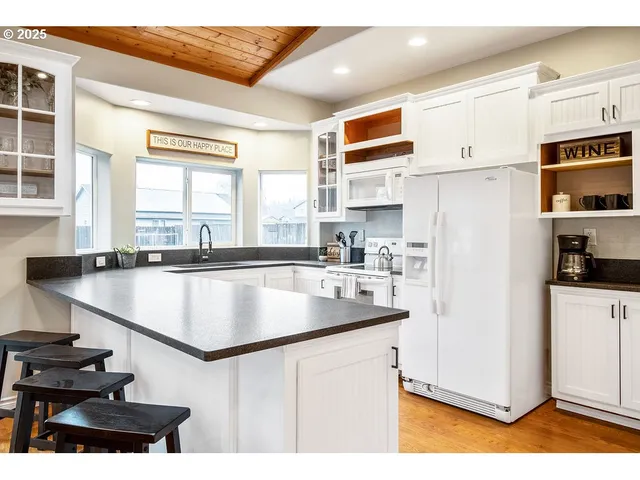 a kitchen with stainless steel appliances granite countertop a sink a stove and a refrigerator