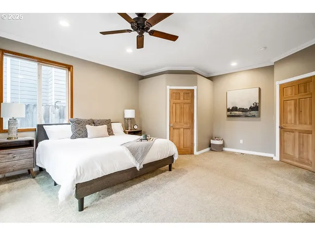 a spacious bedroom with a large bed and a chandelier