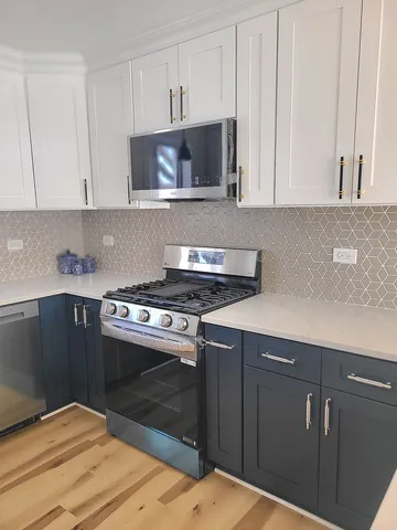 a kitchen with a stove and white cabinets