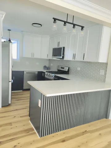 a kitchen with stainless steel appliances a stove top oven a sink and a refrigerator