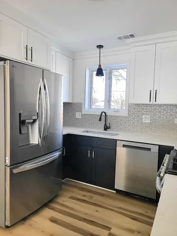 a kitchen with granite countertop a refrigerator and a sink