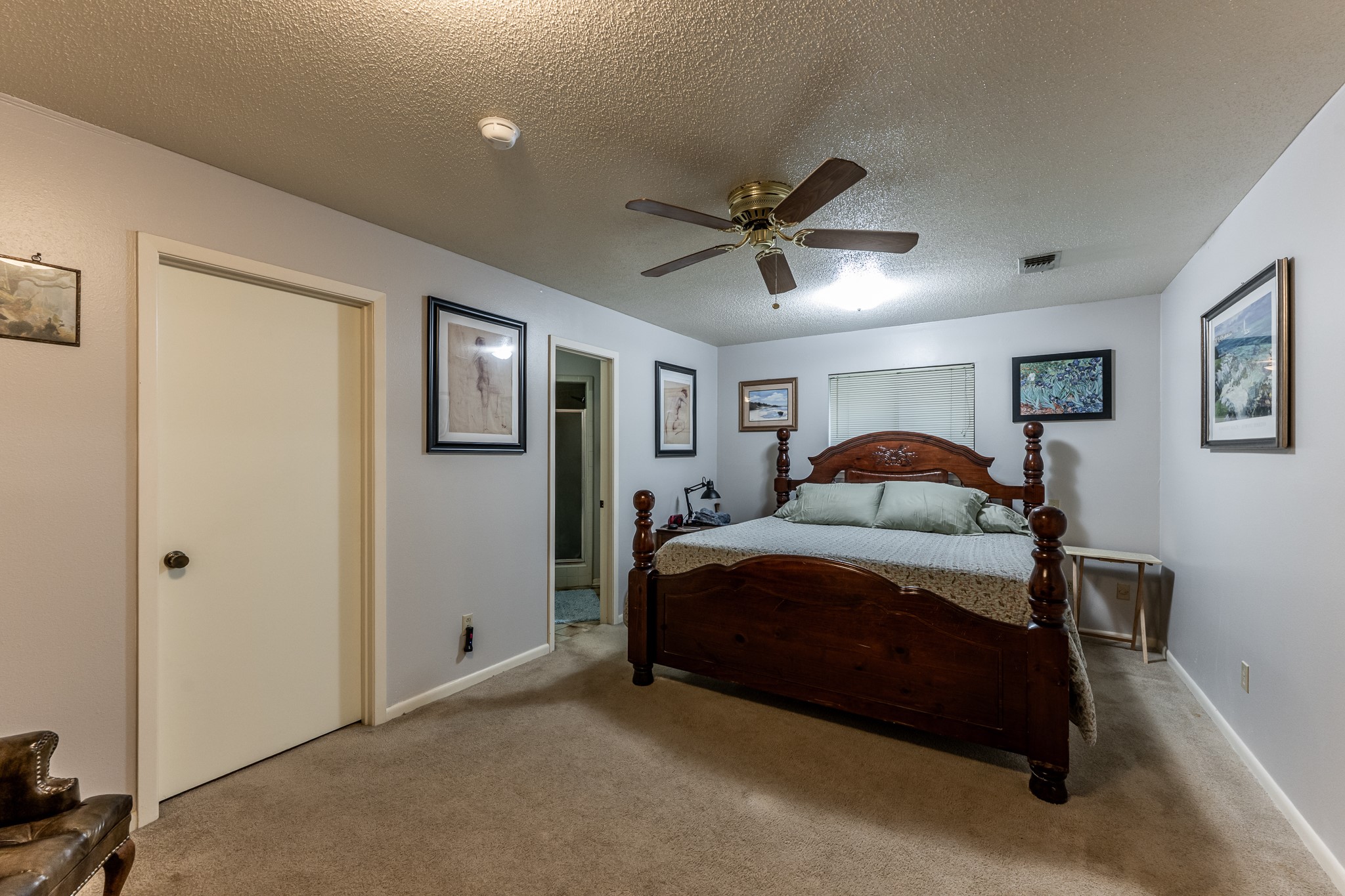 3304 Parr Drive Huntsville, TX 77320 - Photo 20 of 40 a spacious bedroom with a bed and a chandelier