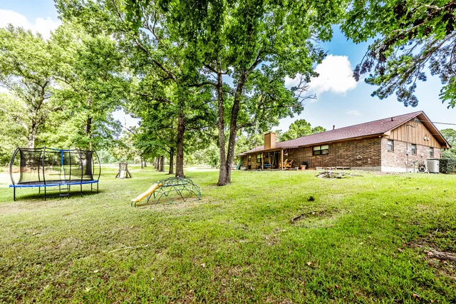 a view of a house with backyard and tree