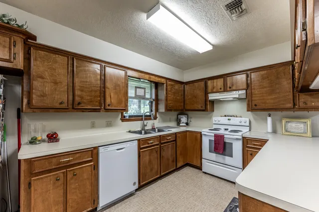 a kitchen with stainless steel appliances a sink stove and cabinets