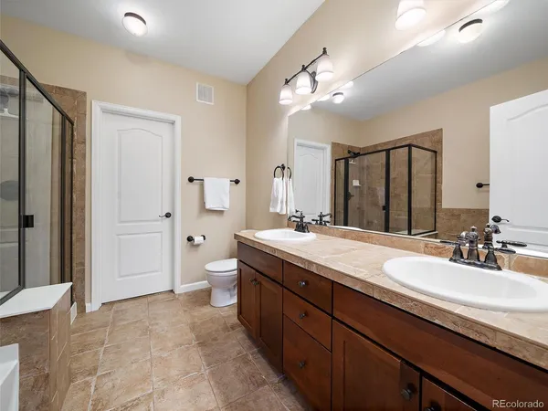 a spacious bathroom with a double vanity sink mirror double and shower