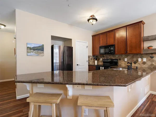 a kitchen with stainless steel appliances granite countertop a refrigerator a stove top oven a sink and dishwasher