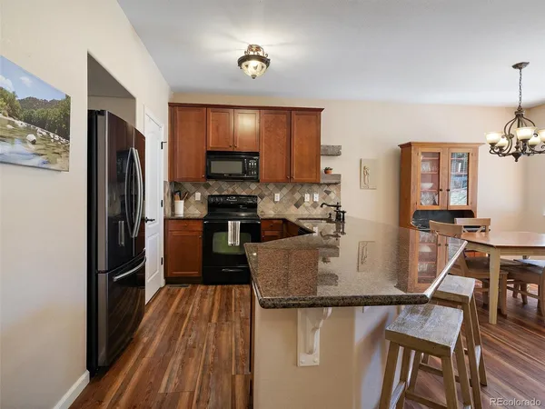 a kitchen with kitchen island a counter top space a sink stainless steel appliances and cabinets