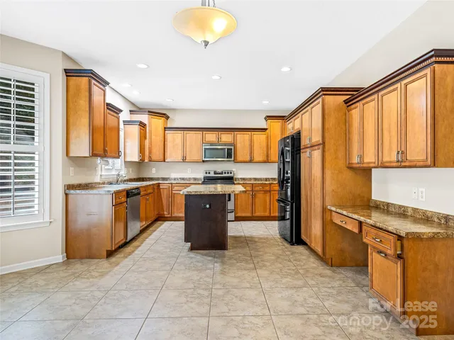a kitchen with stainless steel appliances granite countertop a stove top oven a sink dishwasher and a refrigerator