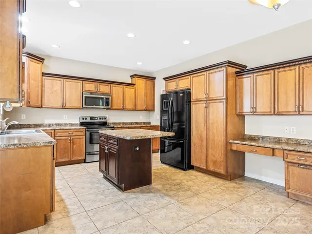 a kitchen with stainless steel appliances granite countertop a refrigerator stove top oven a sink and dishwasher