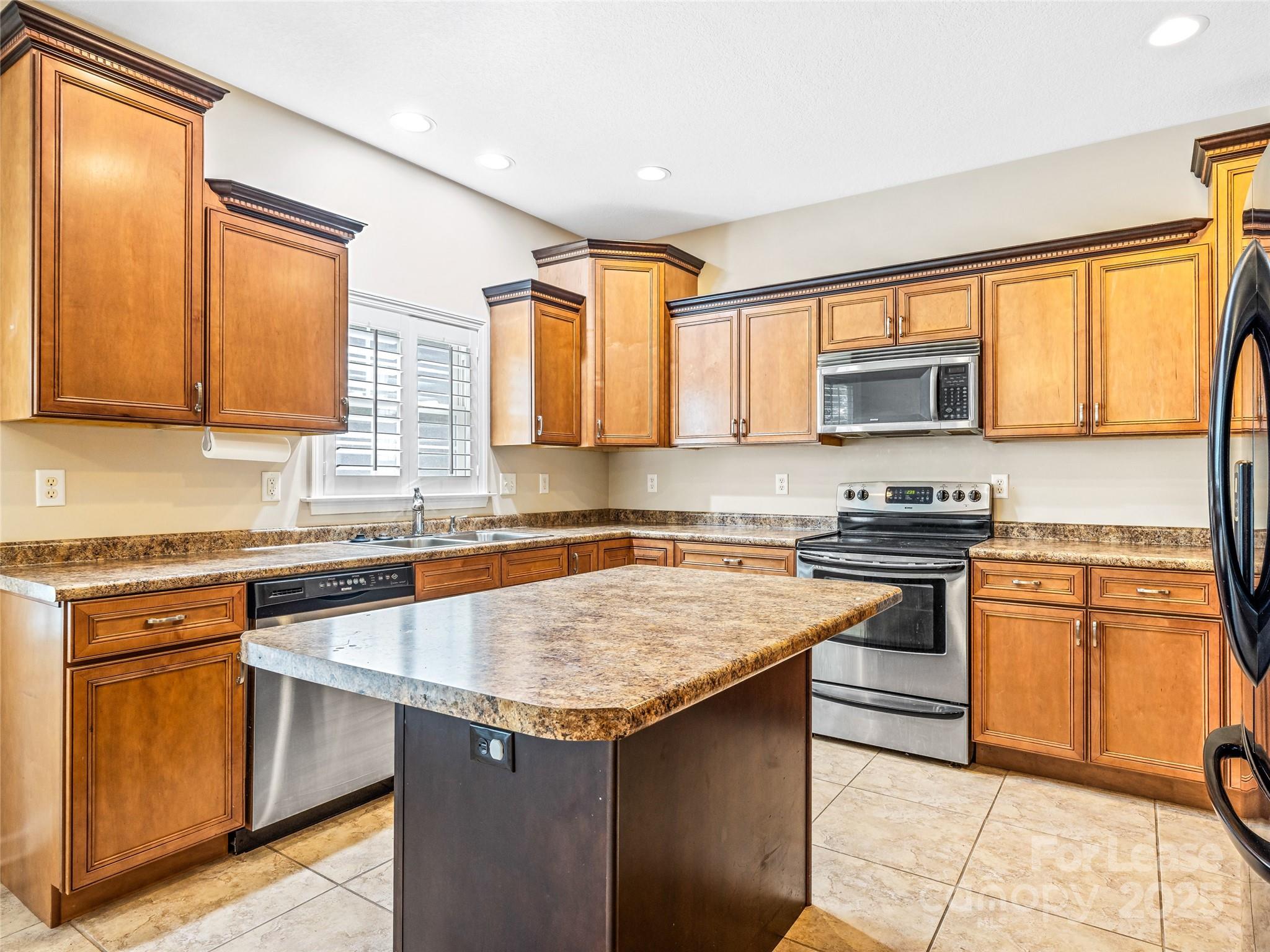 51 Driftstone Circle Arden, NC 28704 - Photo 17 of 38 a kitchen with stainless steel appliances granite countertop a stove a sink dishwasher a microwave oven and a refrigerator with wooden cabinets