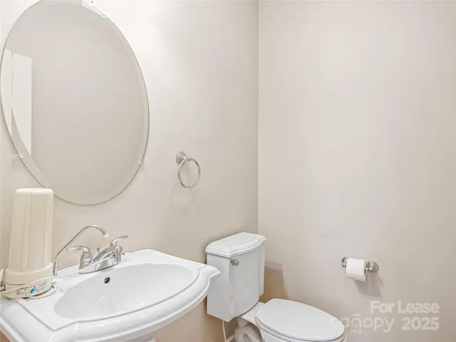 a bathroom with a sink mirror and toilet
