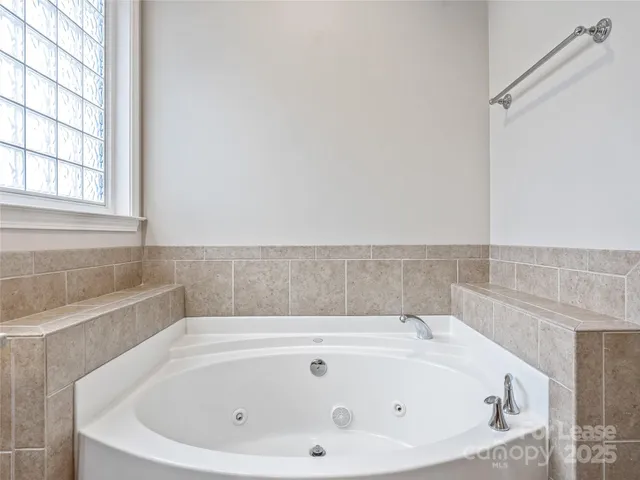 a bathroom with bathtub and window