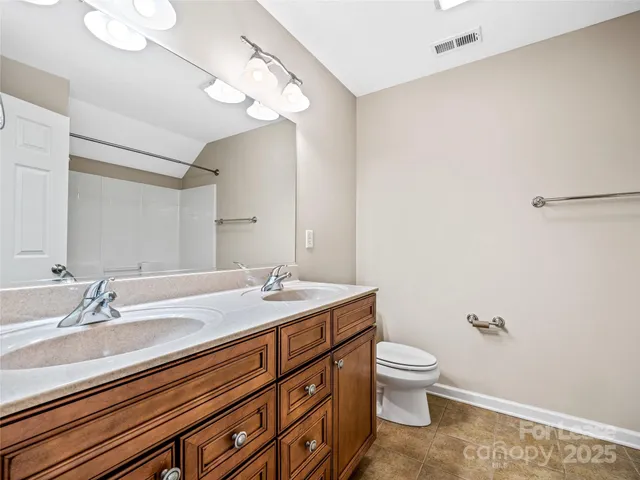 a bathroom with a granite countertop sink a toilet and a mirror