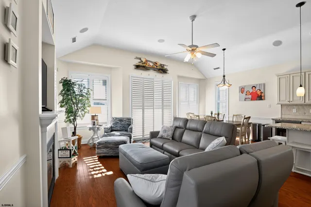 a living room with furniture a ceiling fan and a window