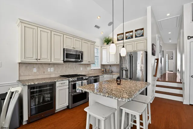 a kitchen with stainless steel appliances granite countertop a stove a sink and a refrigerator
