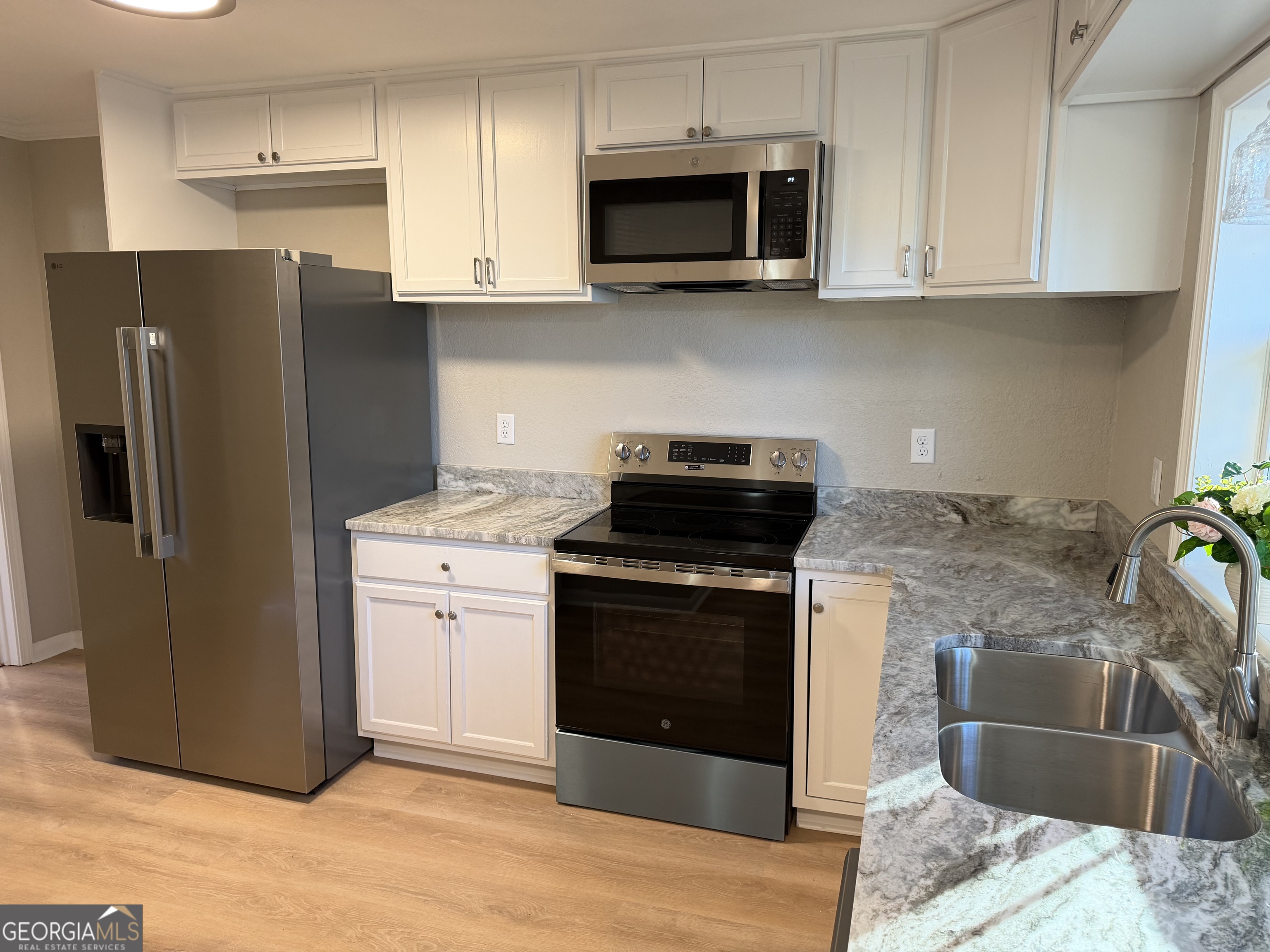 116 Country Club Road Dublin, GA 31021 - Photo 12 of 22 a kitchen with stainless steel appliances granite countertop a stove a refrigerator and a microwave