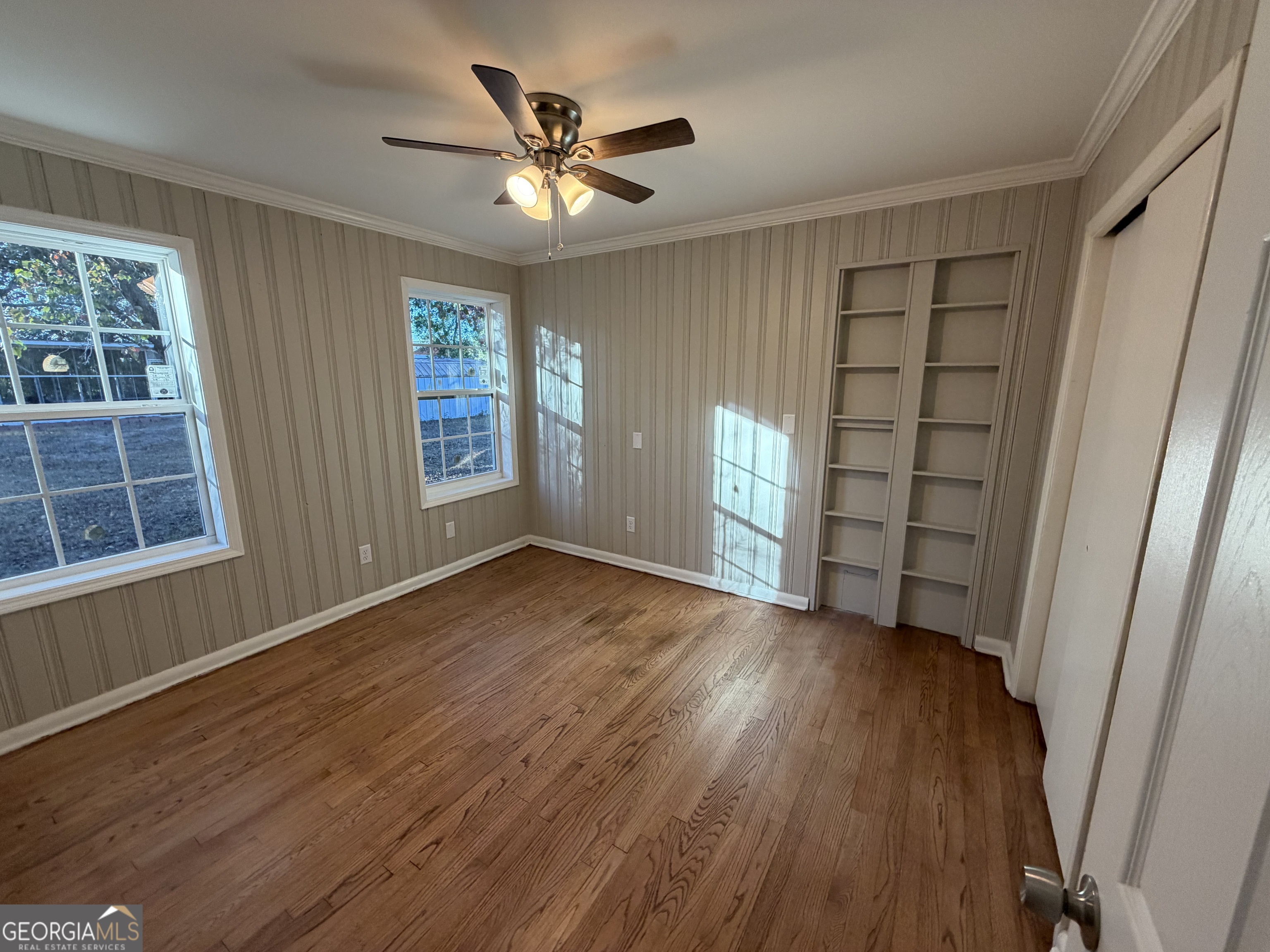 116 Country Club Road Dublin, GA 31021 - Photo 17 of 22 an empty room with wooden floor and windows