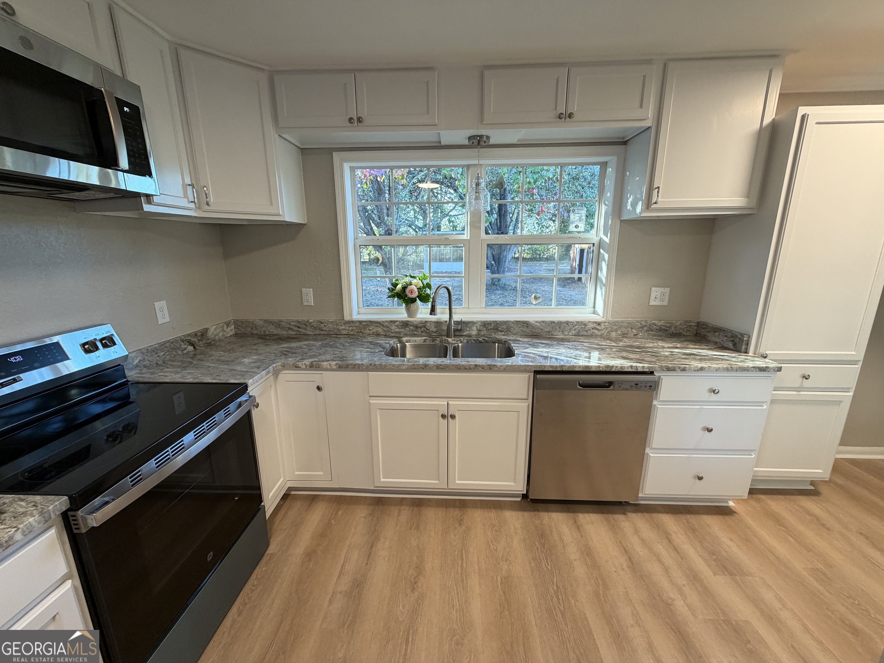 116 Country Club Road Dublin, GA 31021 - Photo 22 of 22 a kitchen with granite countertop a stove a sink and a microwave