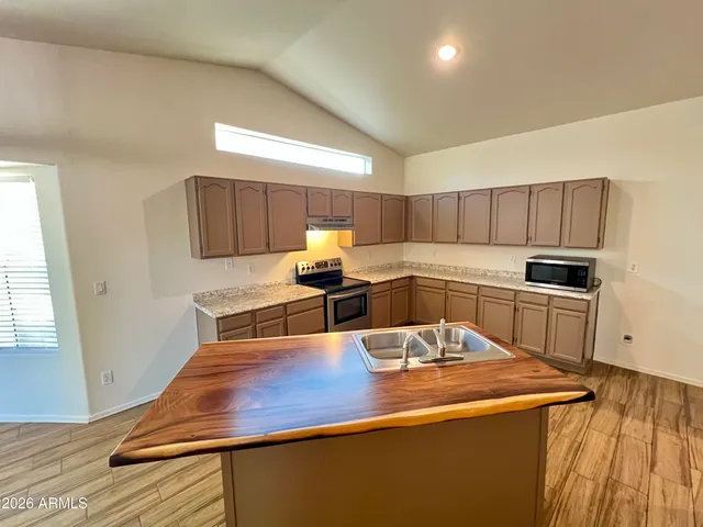 a kitchen with kitchen island a sink appliances and cabinets