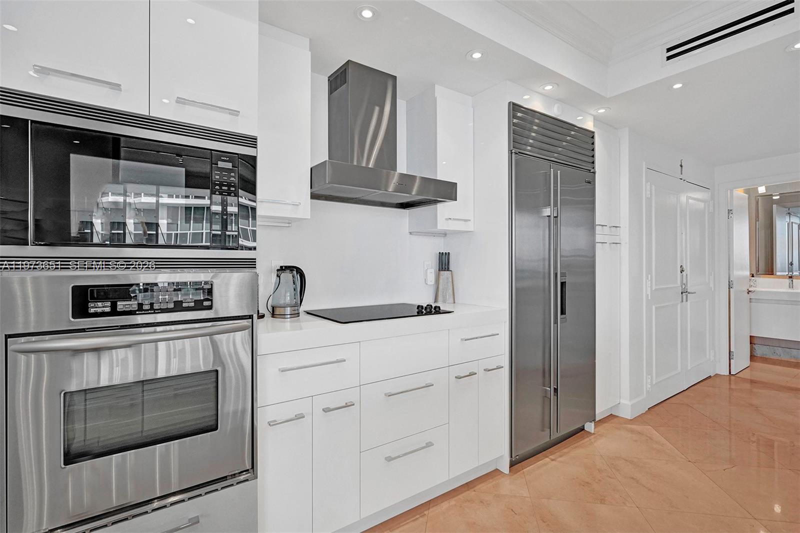 10205 Collins Avenue, Unit P8 Bal Harbour, FL 33154 - Photo 19 of 56 a kitchen with stainless steel appliances granite countertop a refrigerator and a stove top oven