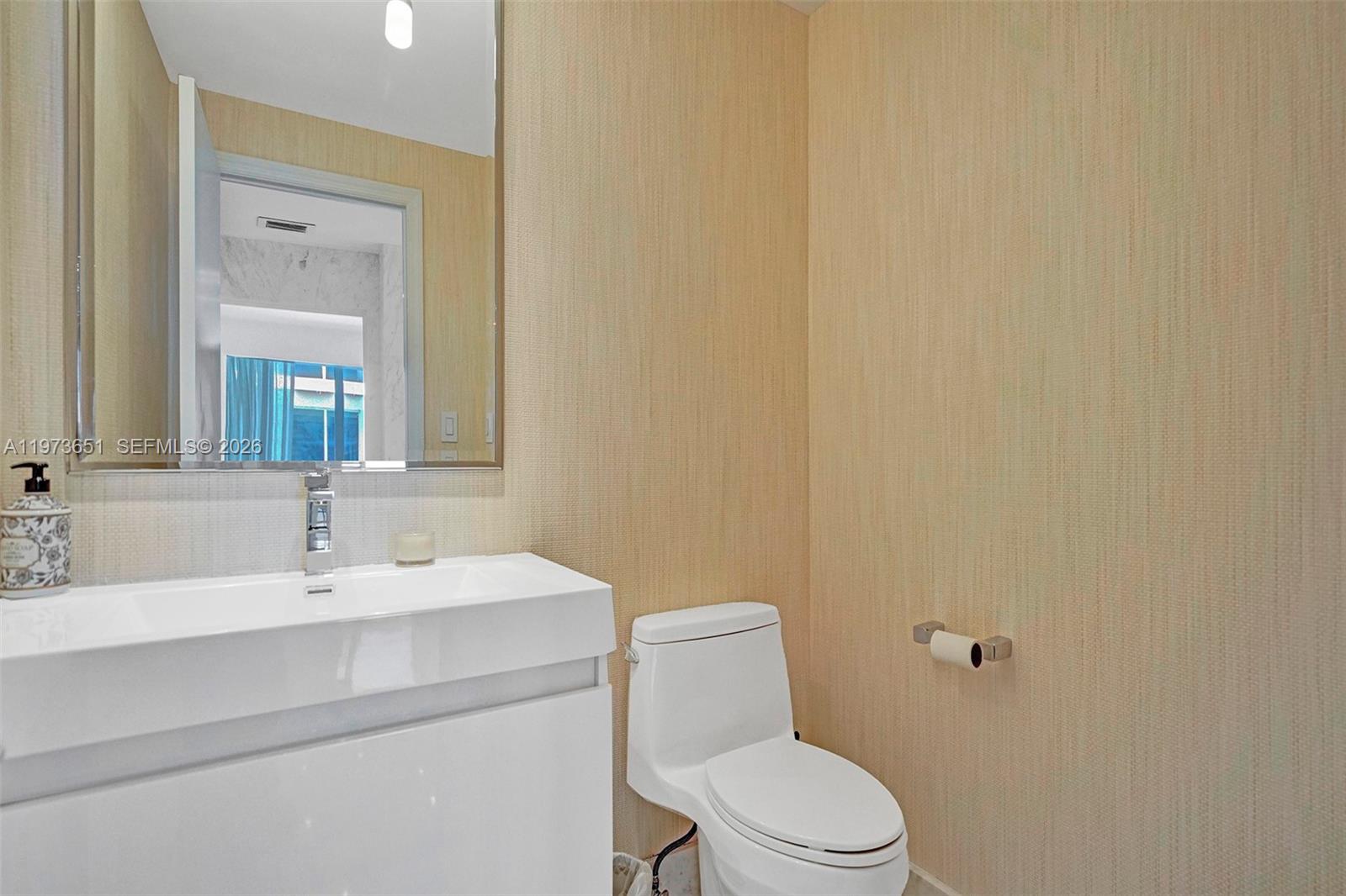10205 Collins Avenue, Unit P8 Bal Harbour, FL 33154 - Photo 26 of 56 a bathroom with a sink mirror vanity and toilet