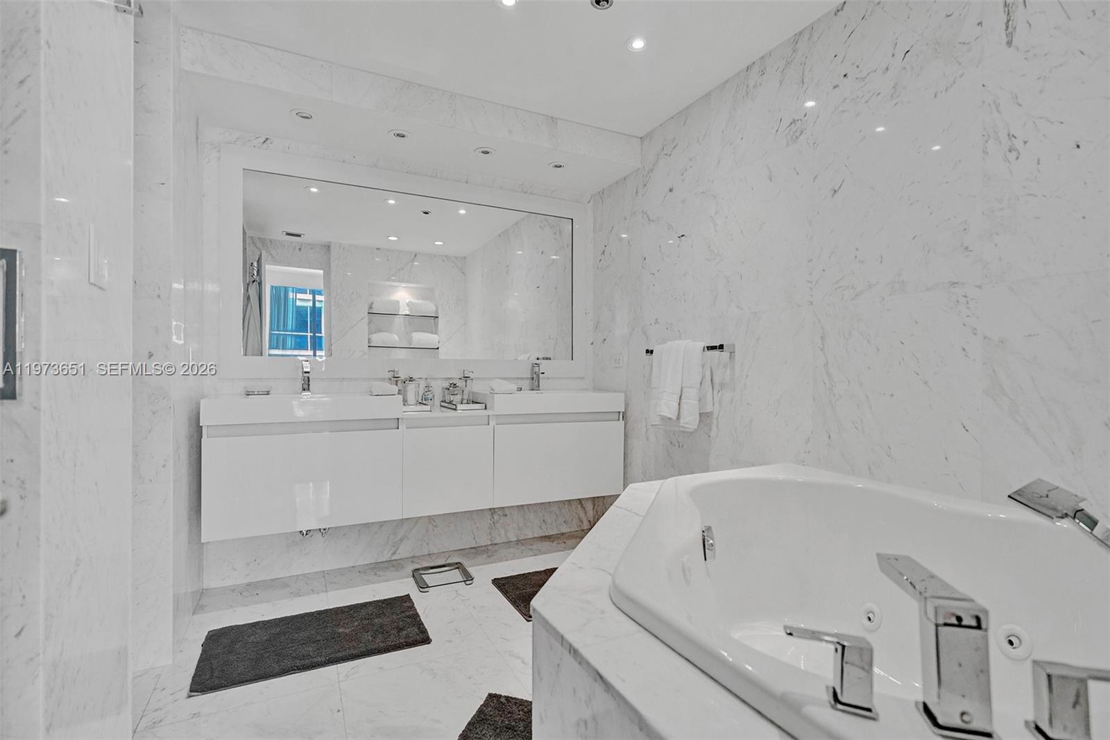 10205 Collins Avenue, Unit P8 Bal Harbour, FL 33154 - Photo 38 of 56 a bathroom with a bathtub sink a toilet and mirror