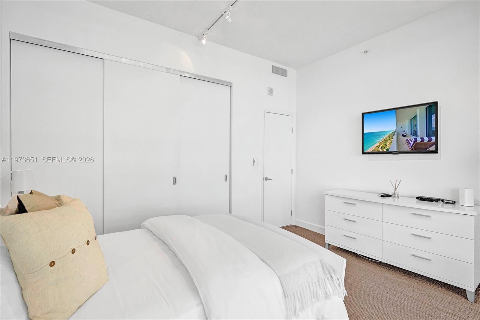 10205 Collins Avenue, Unit P8 Bal Harbour, FL 33154 - Photo 52 of 56 a bedroom with a bed and a chandelier