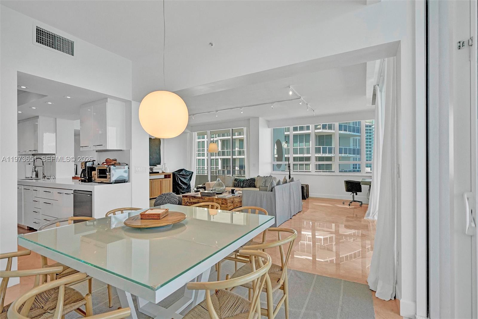 10205 Collins Avenue, Unit P8 Bal Harbour, FL 33154 - Photo 8 of 56 a view of a dining room and kitchen with a table and chairs