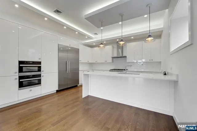 a kitchen with stainless steel appliances a stove a sink and a refrigerator