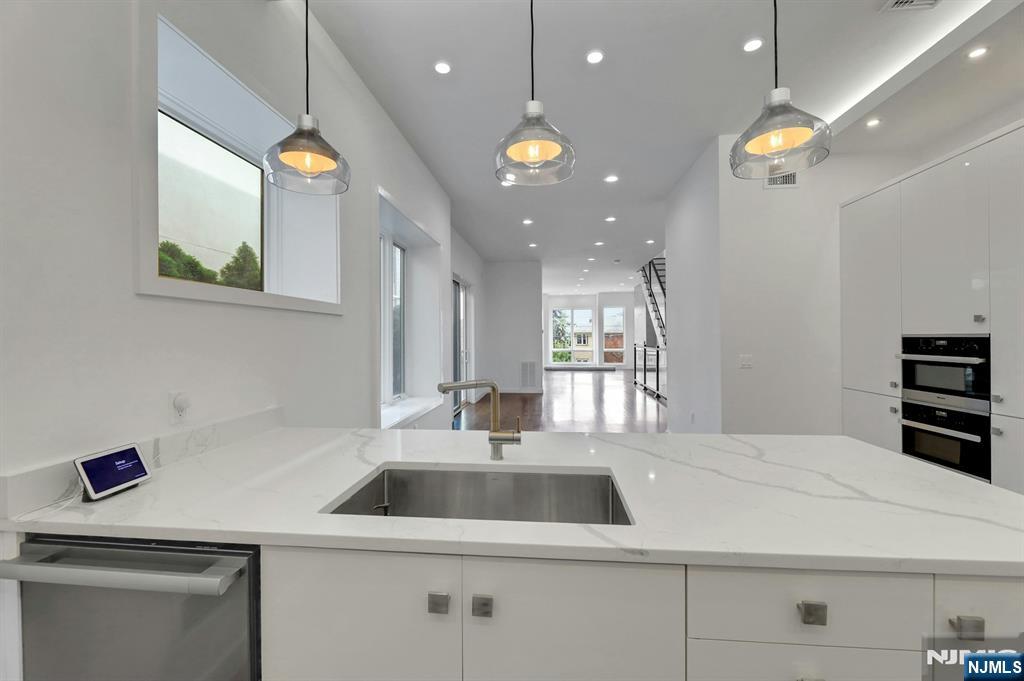 714 Undercliff Avenue, Unit 714 Edgewater, NJ 07020 - Photo 19 of 45 a kitchen with a sink a counter space and stainless steel appliances