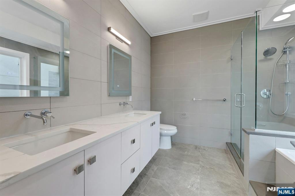 714 Undercliff Avenue, Unit 714 Edgewater, NJ 07020 - Photo 24 of 45 a bathroom with a double vanity sink toilet and shower