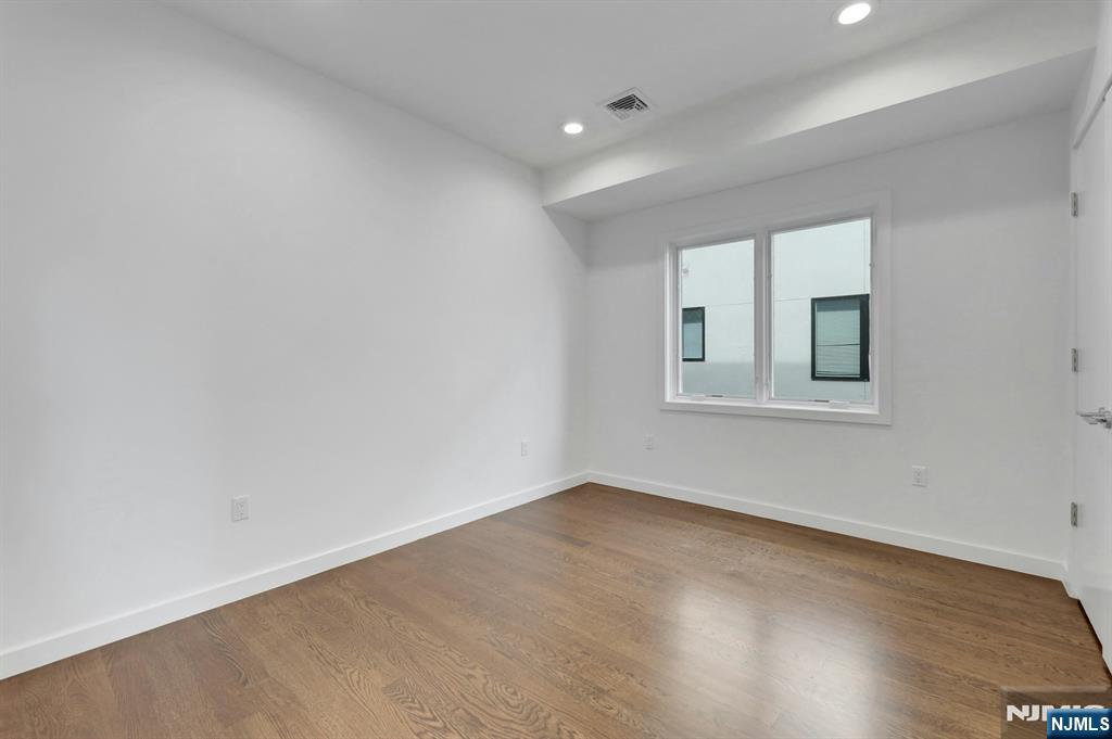 714 Undercliff Avenue, Unit 714 Edgewater, NJ 07020 - Photo 30 of 45 an empty room with wooden floor and windows