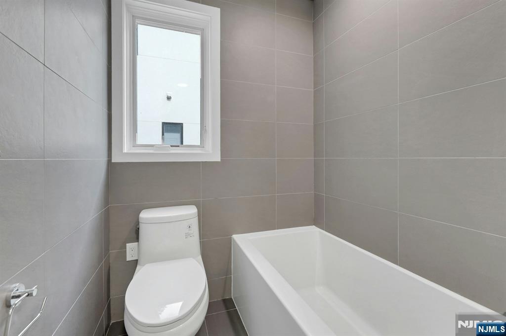 714 Undercliff Avenue, Unit 714 Edgewater, NJ 07020 - Photo 33 of 45 a white toilet sitting next to a white tub