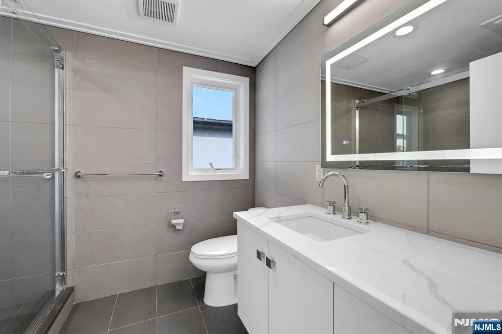 714 Undercliff Avenue, Unit 714 Edgewater, NJ 07020 - Photo 38 of 45 a bathroom with a toilet sink and mirror