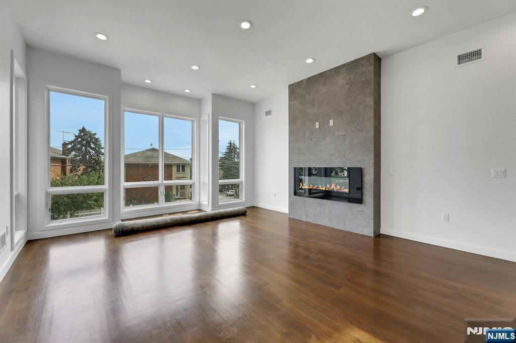 714 Undercliff Avenue, Unit 714 Edgewater, NJ 07020 - Photo 6 of 45 a view of a big room with wooden floor and windows