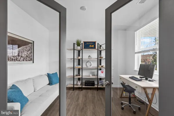 a view of a white house next to a yard with big trees