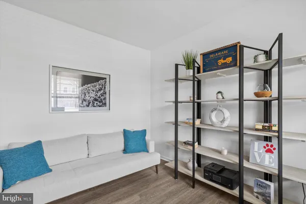 a view of sign board with flower and wooden fence