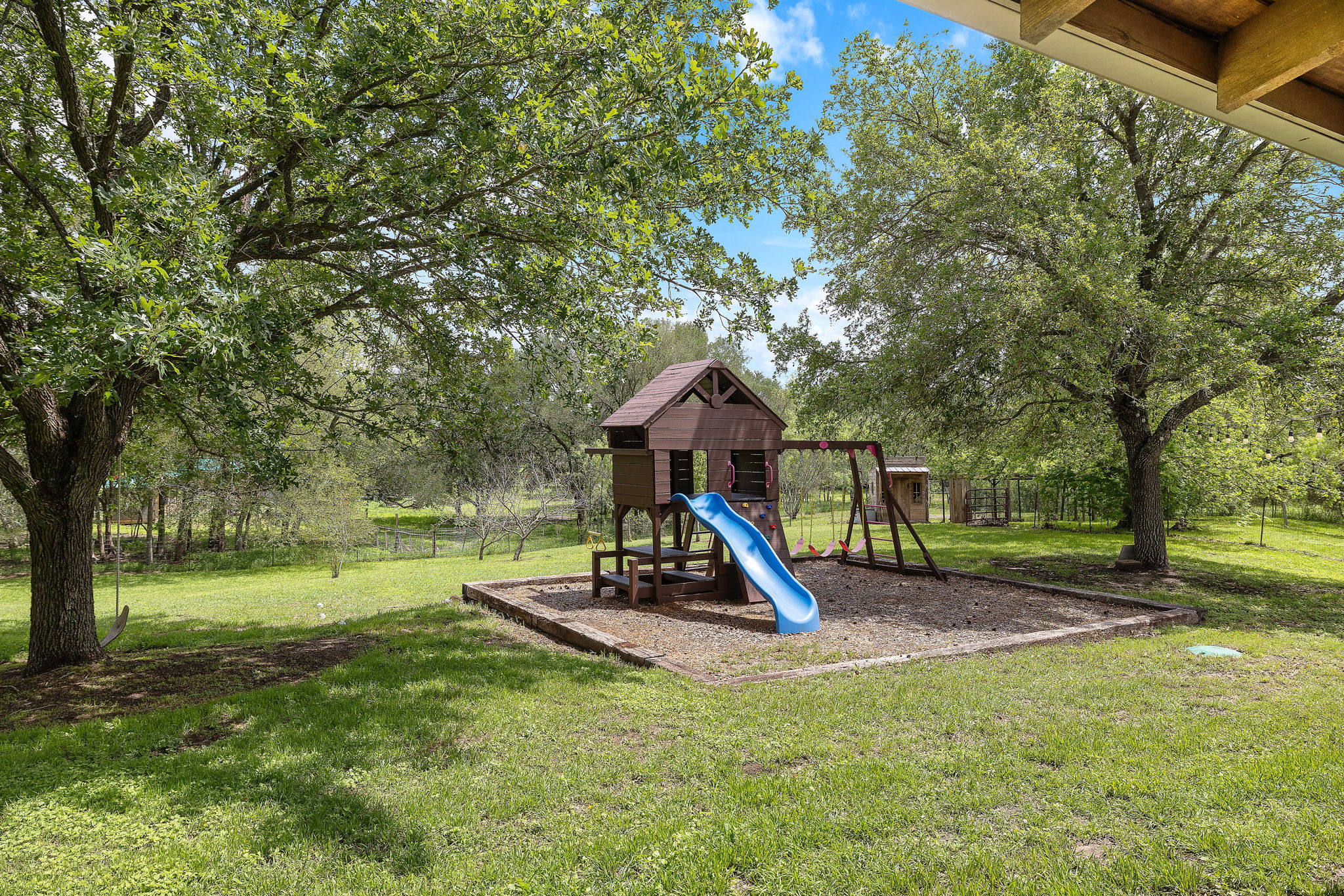 571 Balch Road Elgin, TX 78621 - Photo 22 of 33 Expansive backyard with a dedicated play area, mature trees, and a tree swing