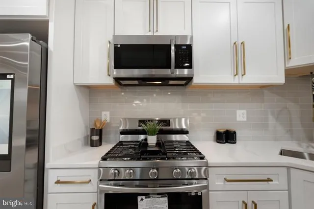 a kitchen with stainless steel appliances a white stove and a microwave