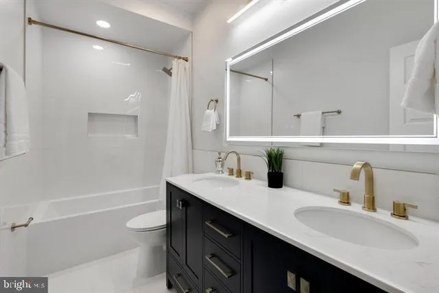 a bathroom with a sink double vanity granite tub shower and a mirror
