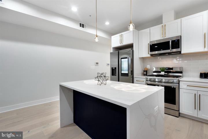 525 Kennedy Street Northwest, Unit 1 Washington, DC 20011 - Photo 9 of 27 a kitchen with stainless steel appliances a sink stove and refrigerator