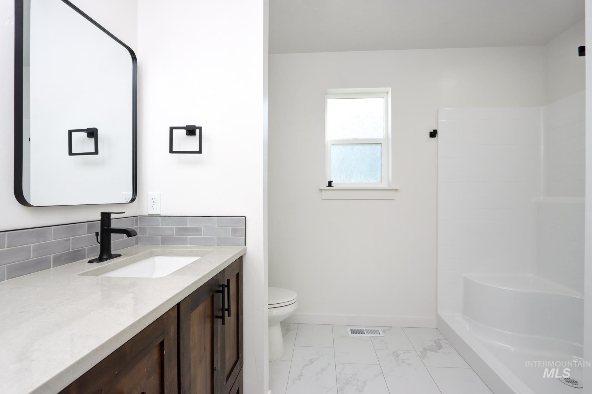 848 North 5th Street Nyssa, OR 97913 - Photo 21 of 49 Bathroom featuring a vanity with dark wood-finish cabinetry, a light-toned countertop, and an undermount sink
