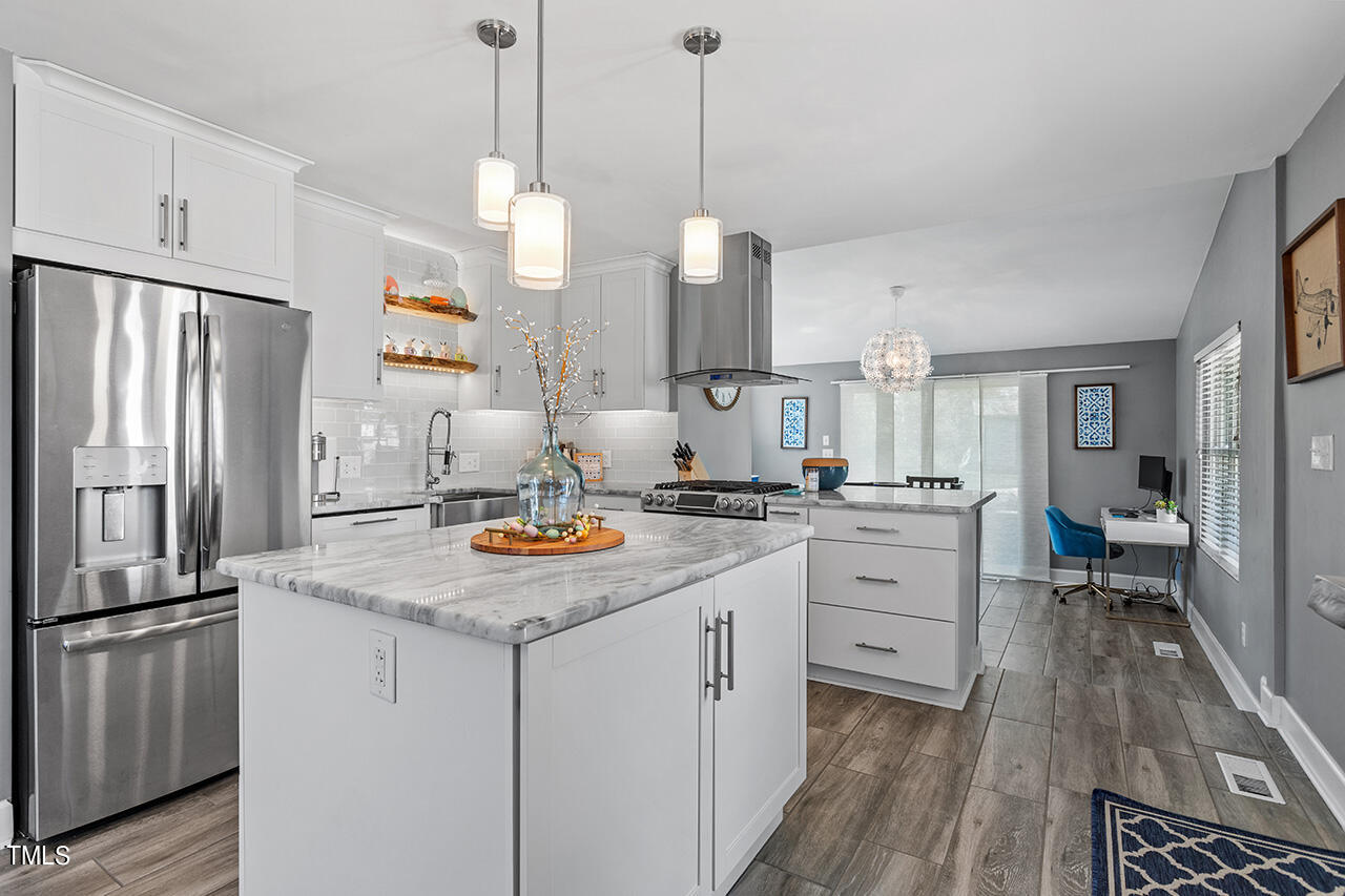 2530 Newbold Street Raleigh, NC 27603 - Photo 5 of 27 a kitchen with white cabinets and stainless steel appliances