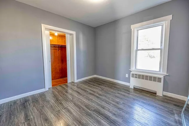 an empty room with windows and closet