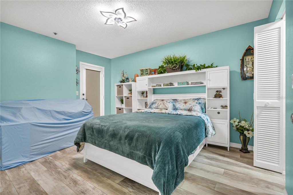 5722 Biscayne Court, Unit 308 New Port Richey, FL 34652 - Photo 18 of 31 a bedroom with a bed and a chandelier