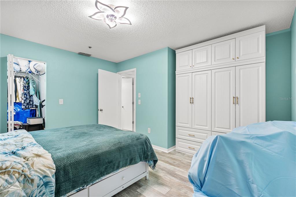 5722 Biscayne Court, Unit 308 New Port Richey, FL 34652 - Photo 19 of 31 a bedroom with a large bed and a chandelier